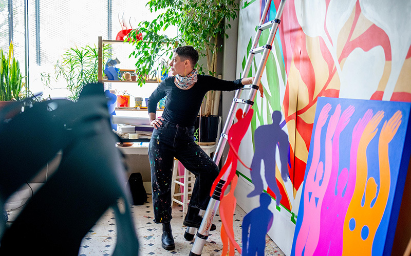 Artist Rose Jaffe in front of a colorful painting